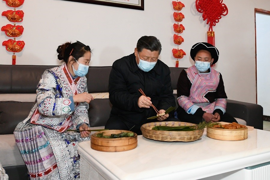 2021年2月3日下午，習(xí)近平在貴州畢節(jié)市黔西縣新仁苗族鄉(xiāng)化屋村苗族村民趙玉學(xué)家，同一家人邊聊家常邊制作當(dāng)?shù)貍鹘y(tǒng)節(jié)日食品黃粑。新華社記者 李學(xué)仁 攝