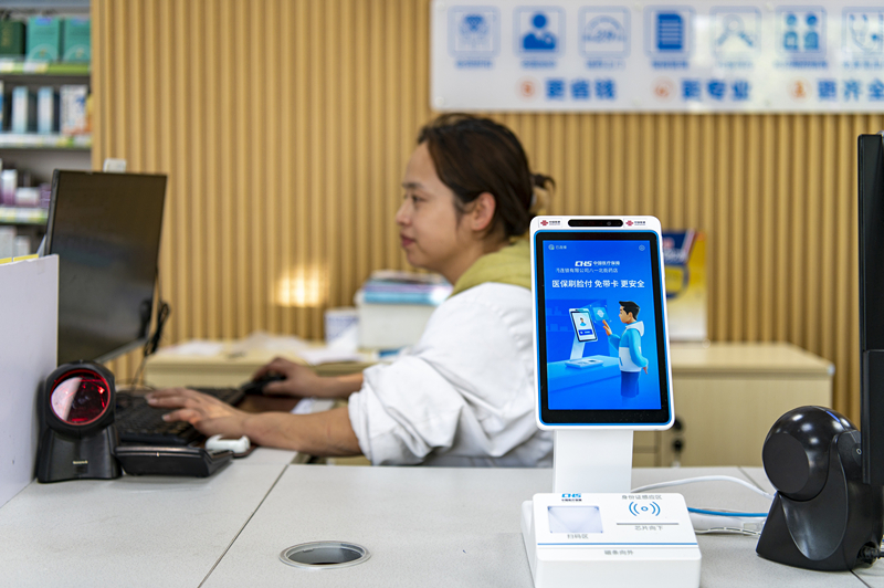 2024年4月10日，浙江金華市區(qū)一家民眾大藥房柜臺上設(shè)置著醫(yī)?！八⒛樦Ц丁睓C(jī)器，群眾看病更加便利。